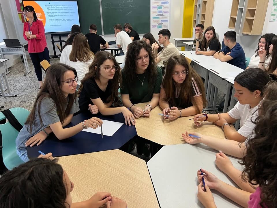 Grup nxënësish duke diskutuar rreth një tryeze