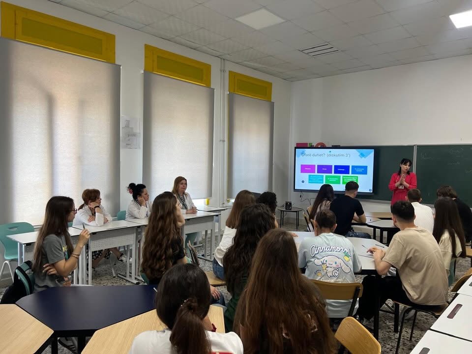 Një lehtësuese duke prezantuar para një klase